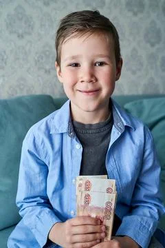 The boy holds a bundle of Russian five-thousand-dollar bills in his hands Stock Photos