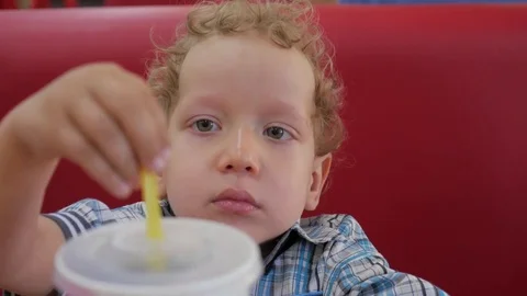 The boy holds a glass with a straw Stock Footage 81564448