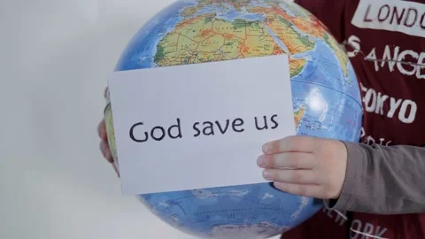 Boy holds a globe, a model of the planet Earth. Child is holding a sign with Stock Footage 131258631