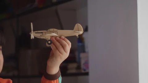 Boy holds in hand in the face of a model airplane 스톡 동영상 88438068
