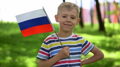 Boy holds Russian flag, background residential buildings. Patriotism, Russia day Stock Footage 202302682