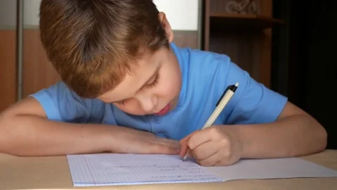A boy at home writes with a pen in a notebook Stock Footage 149767155