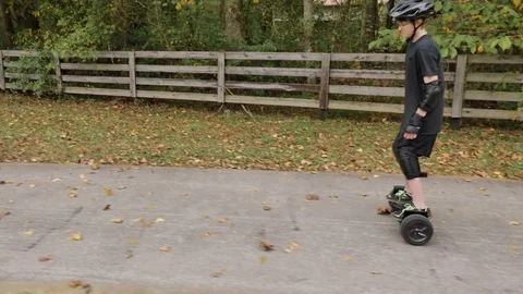 A Boy on a Hoverboard Steady Tracking Shot from the Side Stock Footage 82168282