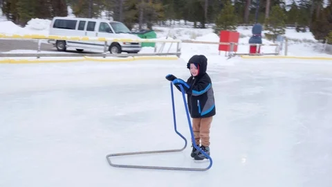 A boy ice skating with his family Stock Footage