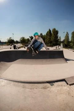 Boy with inline skates, rollerblade, doing a jump in a skate park Stock Photos