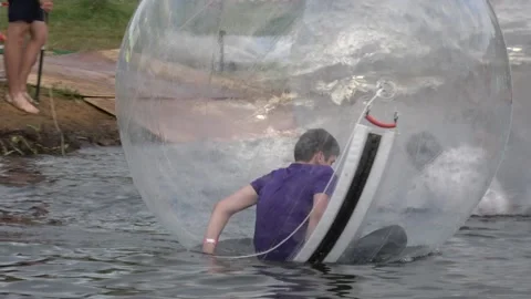 Boy inside the large transparent ball on the water Stock Footage 99082230