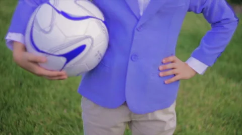 Boy in Jacket Holds Soccer Ball Under His Arm Stock Footage 64524264