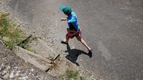 Boy jogging down a road Stock Footage 112083318