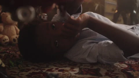 Boy joyfully plays with a retro toy airplane in a cozy indoor setting Stock Footage 319913842