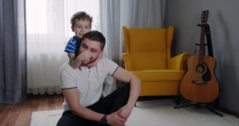 A boy joyfully rides on a mans shoulders, covering his eyes Stock Footage 307297959
