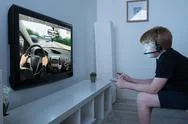 Boy With Joystick Playing Car Game On Television At Home Stock Photos