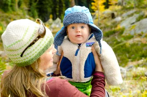 A boy is juggled by his mom while fall hiking in the Purcell Mountains near Stock Photos