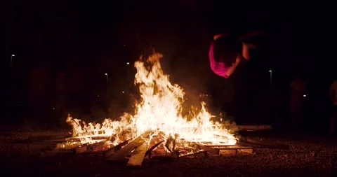 Boy jump make a sideflip in bonfire in the night Stock Footage 277351662