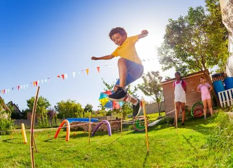 Boy jump over strings passing course of obstacles Stock Photos