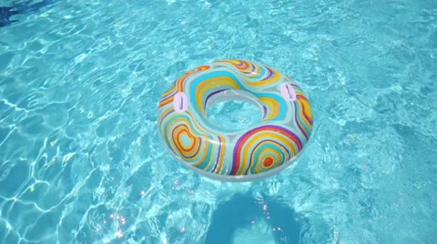 The boy jumped into pool through colored inflatable circle toy Stock Footage 35235245