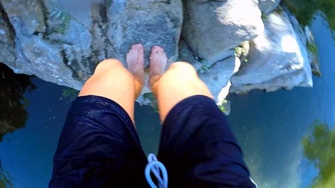 A boy jumped into the river from the high rocks Stock Footage 114623176