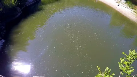 A boy jumped into the river from the high rocks Stock Footage 114623624