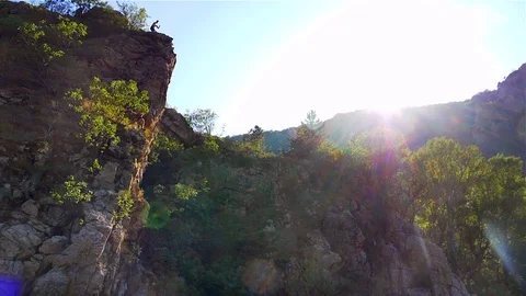 A boy jumped into the river from the high rocks Stock Footage 114623916