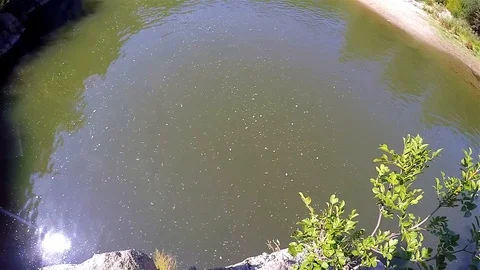 A boy jumped into the river from the high rocks Stock Footage 114624001