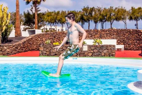 Boy  jumping in the blue pool Stock Photos