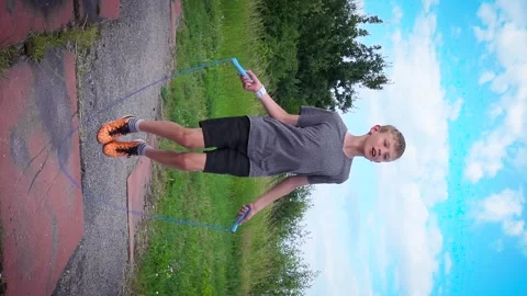 A boy is jumping on a blue rope Stockbeeldmateriaal 277408857