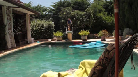 Boy jumping off of diving board Stock Footage 25686995