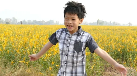 Boy jumping in flower field Stock Footage 62352646
