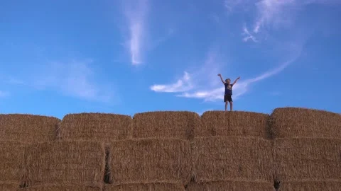 Boy jumping on a haystack against the sky Stock Footage 138267162
