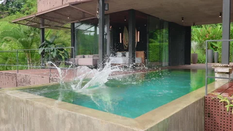 Boy Jumping into Infinity Pool at Modern Tropical Villa in Slow Motion. Stock Footage 338364704