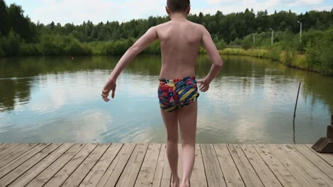 Boy jumping into the lake from the pier Stock Footage 206760055