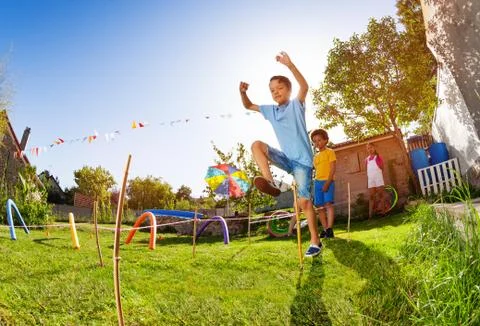 Boy jumping over string in competition game Stock Photos
