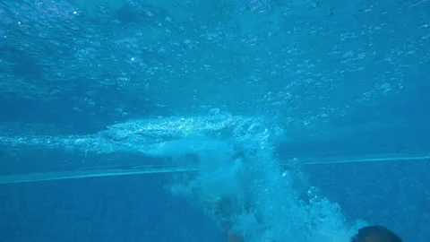 Boy jumping in the pool, submerging and pulling himself up Stock Footage 154232700
