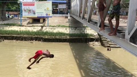 A boy jumping into the river Ganga in a mid noon of summer Video stock 115694447