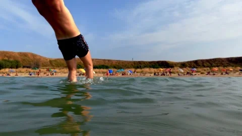 Boy jumping to save ball in sea water Stock Footage 277552203
