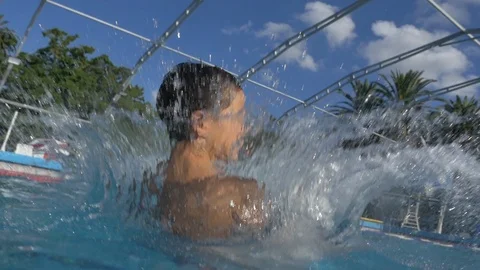 Boy jumping from springboard and diving in Swimming Pool -Slow Motion- Stock Footage 105262310