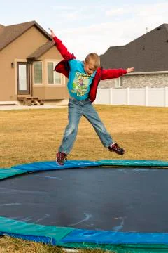 Boy Jumping On Trampoline Looking Down Stock Photos