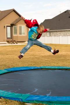 Boy Jumping On Trampoline Stock Photos