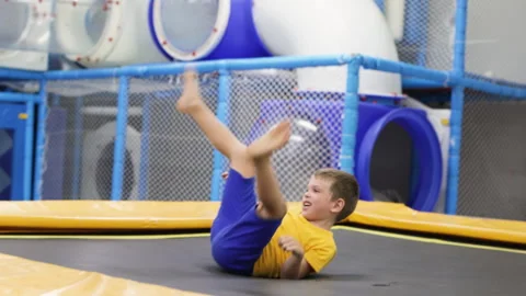 Boy jumping on trampoline in playground. Stock Footage 264274153