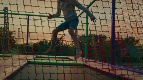 Boy Jumping on Trampoline in Playground Stock Footage 313561918