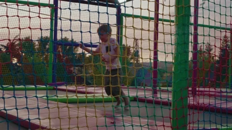 Boy Jumping on Trampoline in Playground, Slow Motion Stock Footage 313558243
