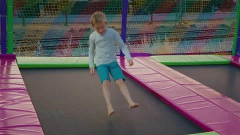 Boy Jumping on Trampoline in Playground, Slow Motion Stock Footage 313592678