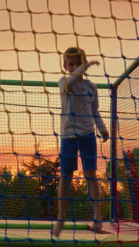 Boy Jumping on Trampoline in Playground. Vertical video Stock Footage 313779230