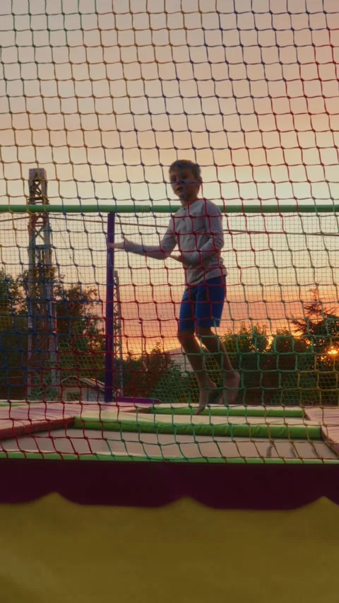Boy Jumping on Trampoline in Playground. Vertical video, slow motion Video stock 313779301