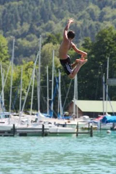 Boy jumping into water Stock Photos