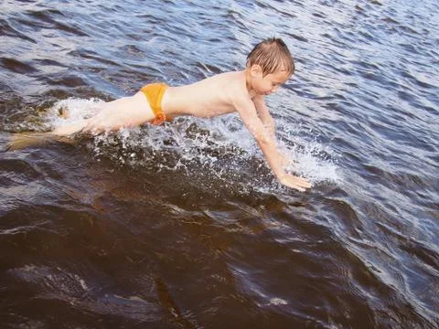 Boy jumping in the water Stock Photos