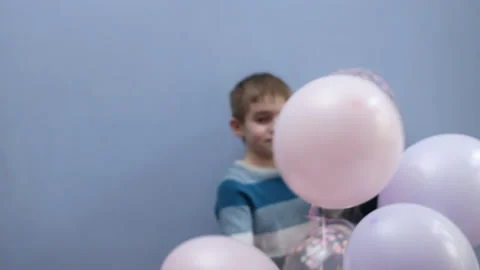 A boy jumps and has fun with a bunch of balloons Stock Footage 193733373