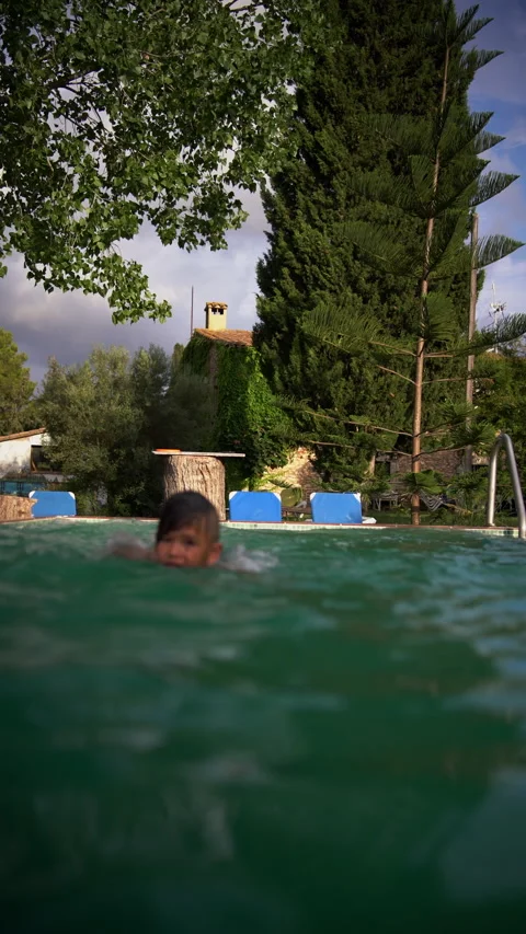 Boy Jumps Into Pool and Swims Toward the Camera Stock Footage 344915491