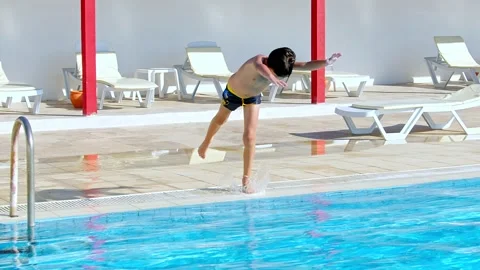 A Boy Jumps Into the Pool Stock Footage 216642857