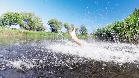 The boy jumps into the river. Slow motion. Stock Footage 79143435