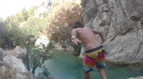 Boy Jumps off Rocks into River Video stock 43053559
